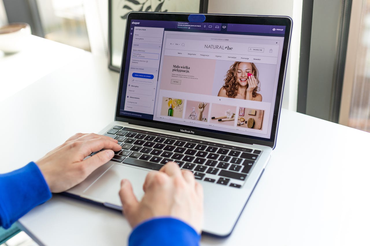 who-we-are Hands typing on a laptop with an e-commerce website open, showcasing online shopping.